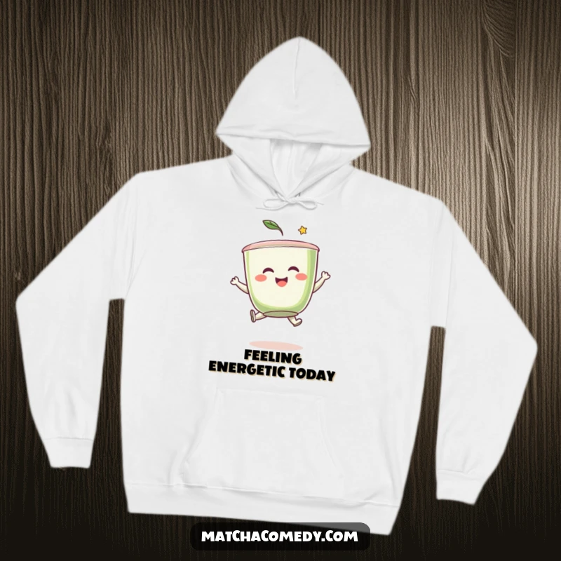 Funny matcha tea cup character caught mid-leap with a beaming smile, offering warmth and whimsical humor on a cozy hoodie.